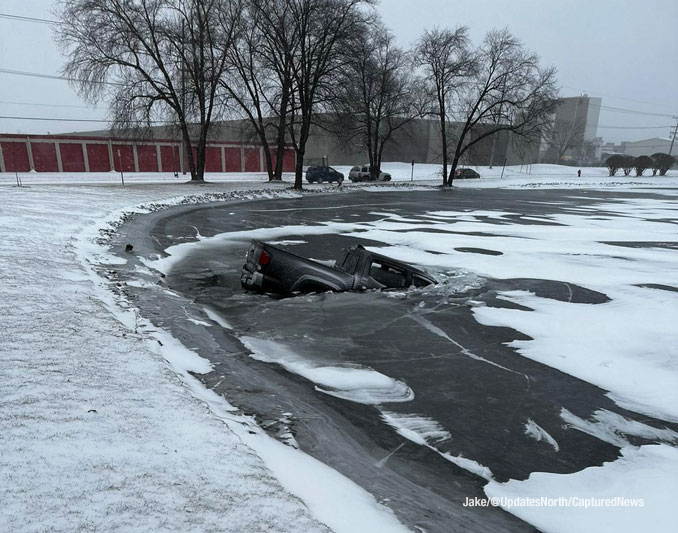 A Chevy pickup truck broke through the ice on the surface of a pond when the driver lost control of the truck in wintry weather at Mount Prospect Road and Howard Street in Des Plaines (PHOTO CREDIT: Jake/@UpdatesNorth/CapturedNews)