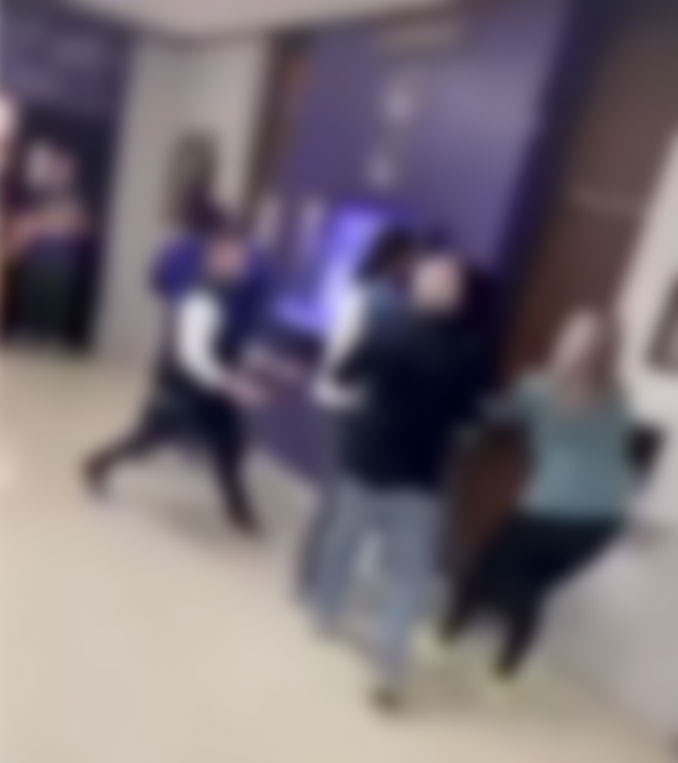 Blurred image of a hallway fight inside Rolling Meadows High School captured from cell phone video.