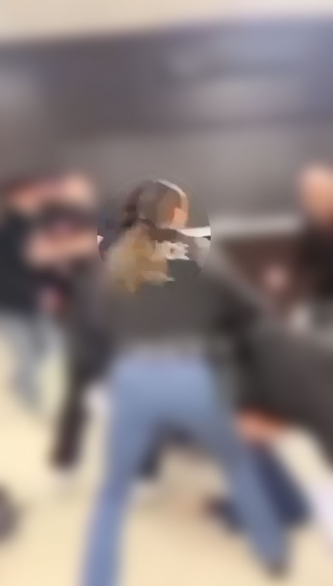 Blurred image of a hallway fight inside Rolling Meadows High School captured from cell phone video.