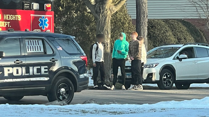 Teens behind an ambulance gesture to another teen being assessed by paramedics in the back of an ambulance on Dryden Avenue near Jules Street in Arlington Heights Monday, February 6, 2023