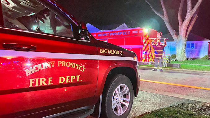 MPFD Battalion 3 on the driveway across the street from a house fire in the block of 300 North Owen St. in Mount Prospect on Thursday, April 13, 2023.