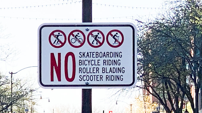 No skateboarding, no bicycle riding, no rollerblading, and no scooter riding posted sign on VL Ave. at the entrance to Arlington Alfresco