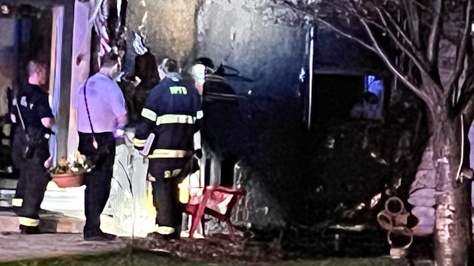 Fire investigators check the front of the house on Owen St., Thursday, April 13, 2023