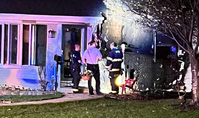 Fire investigators check the front of the house on Owen St., Thursday, April 13, 2023