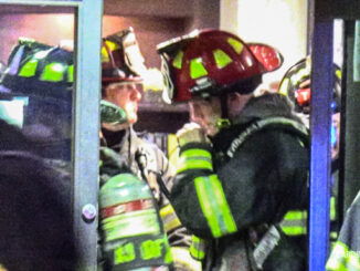 A fire lieutenant communicates on a portable radio while in the lobby coordinating fire operations.