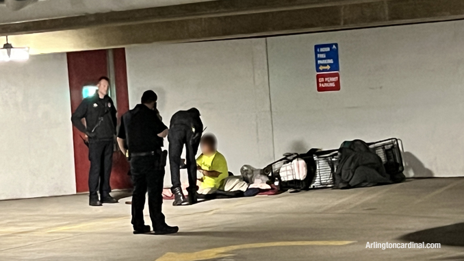 Paramedics apparently getting a signed medical release from a  man who camped out in the southeast corner of the underground parking garage at 33 South Evergreen Avenue in Arlington Heights