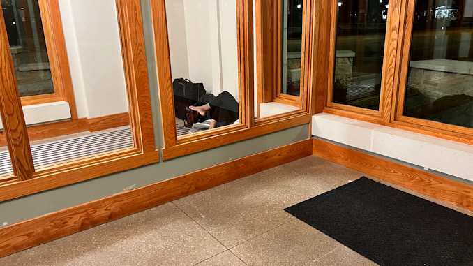 One of two people camped out and sleeping in the Arlington Heights police station vestibule overnight in early May, 2023.