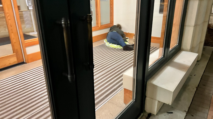 One of two people camped out and sleeping in the Arlington Heights police station vestibule overnight in early May, 2023