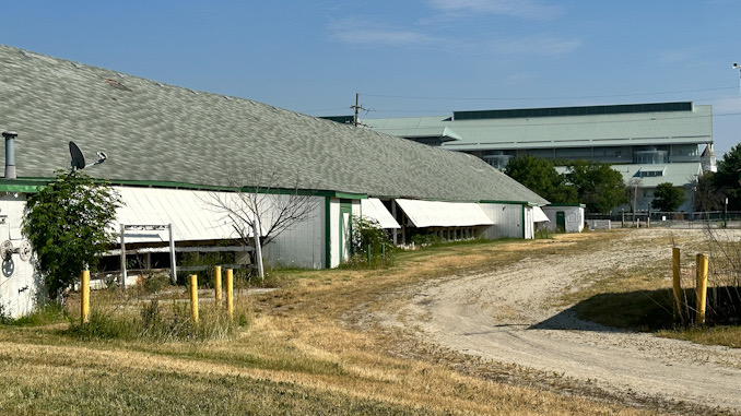 A look at the vacant backstretch with the grandstand in the background (the backstretch is the area adjacent to a racetrack where the horses are stabled and stable employees have temporary housing)