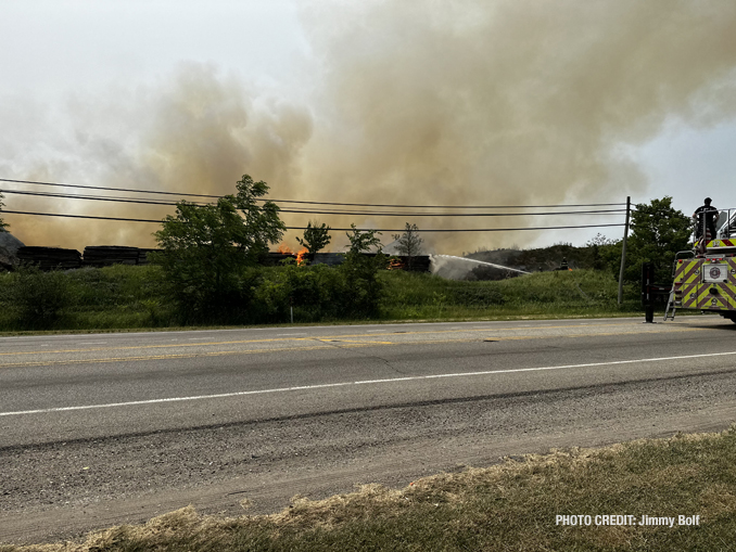 Firefighters working to extinguish burning mulch at Route 120 and Wilson Road in Grant Township near Round Lake (PHOTO CREDIT: Jimmy Bolf).