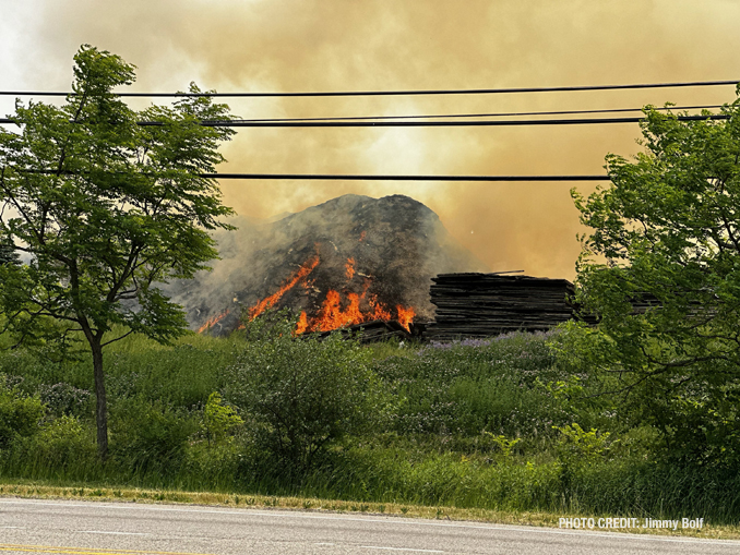 Firefighters working to extinguish burning mulch at Route 120 and Wilson Road in Grant Township near Round Lake (PHOTO CREDIT: Jimmy Bolf).