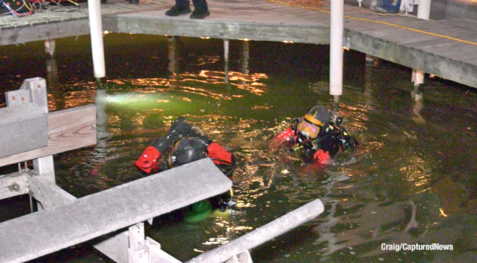 Divers near a pier in the Long Channel between Spring Lake and Petite Lake search for a man who drowned after jumping in the channel (SOURCE: Craig/CapturedNews)