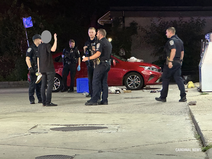 Police talking with one of the victims from the red Kia Forte at the scene of a fight with injuries at the Mobil gas station 102 West Northwest Highway in Arlington Heights, Thursday, July 6, 2023 (CARDINAL NEWS)