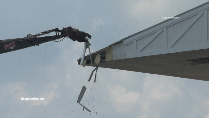 Debris falls as high-reach jaws bite into a corner of the grandstand at Arlington Park race track in Arlington Heights on Wednesday, July 5, 2023 (CARDINAL NEWS)