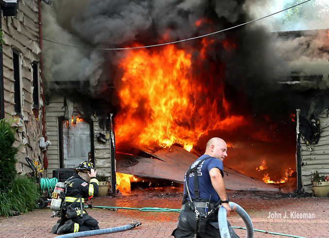 Firefighters advancing hose lines at a garage fire on Hill Road in Palatine on Wednesday evening, July 19, 2023 (PHOTO CREDIT: John J. Kleeman)