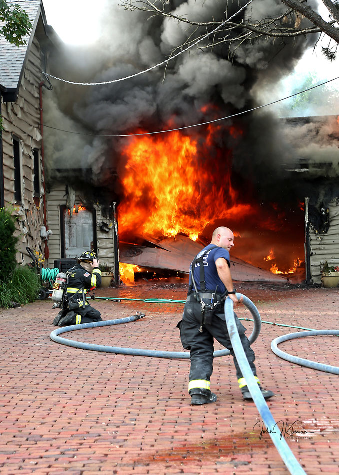 Firefighters advancing hose lines at a garage fire on Hill Road in Palatine on Wednesday evening, July 19, 2023 (PHOTO CREDIT: John J. Kleeman)