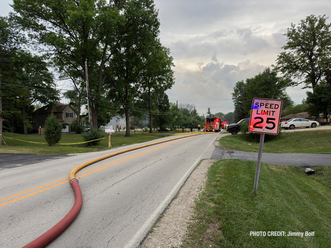 Hose line down the street after a house explosion in Lisle, Illinois with a gas-fed fire on Saturday, July 1, 2023 (PHOTO CREDIT: Jimmy Bolf).