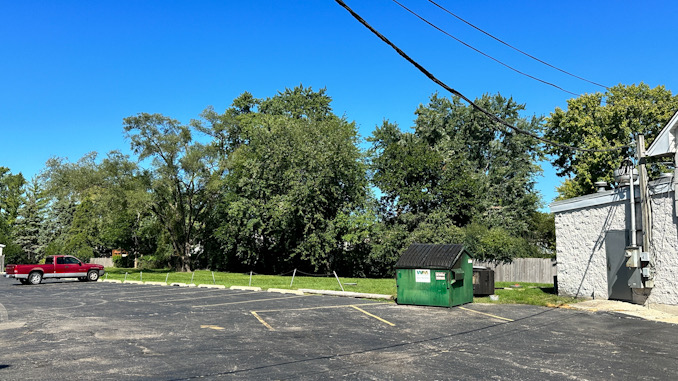 Tree line behind Crave Bar in the direction where a bullet traveled during the night and entered a house when two people were also wounded in a shooting outside the Crave Bar on July 1, 2023 (CARDINAL NEWS)