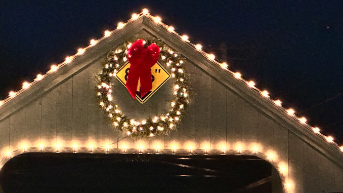 A Christmas or holiday wreath near the top of the Long Grove covered bridge covering the 8'6" clearance warning sign overnight Saturday and Sunday November 18-19, 2023. 