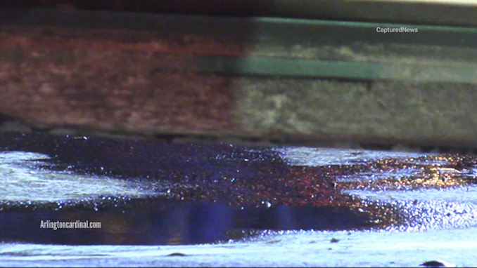Blood under the driver's side door of the white Infiniti parked at the front door of the Shell gas station at River Road and Rand Road in Mount Prospect during investigation early Monday morning January 22, 2024 (CARDINAL NEWS)