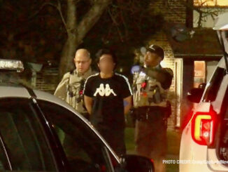 Cook County Sheriff's deputies transfer a male in custody in handcuffs from inside an apartment building to sheriff's police vehicle (PHOTO: Craig/CapturedNews)