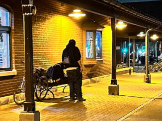 A male adult hangs his head forward while sitting on a bench on Platform 2 near the Metra train station on Wednesday night, April 17, 2024