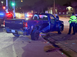 A large blue pickup truck with passenger side damage from a crash located in the westbound lanes of the Town & Country shopping center exit, and located partially in Arlington Heights Road Thursday night, April 17, 2025 (CARDINAL NEWS)
