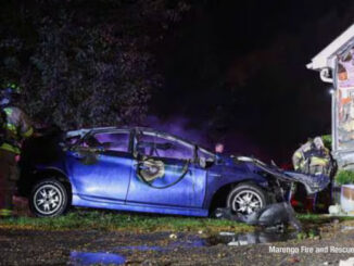 Wreckage of blue 4-door sedan with fire damage next to a residential garage on River Road in Marengoinvolved in a single-vehicle fatal crash on Monday, October 13, 2025 (Marengo Fire and Rescue Districts)