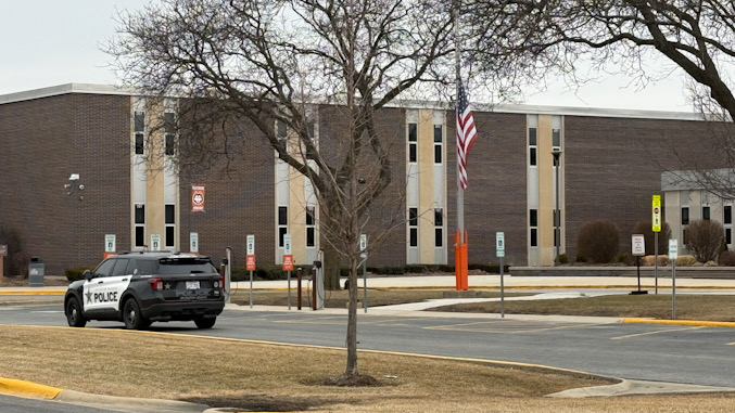 Arlington Heights police officer in SUV Ford Interceptor completing report of incident near Thomas Street and Waterman Avenue at John Hersey High School (CARDINAL NEWS)