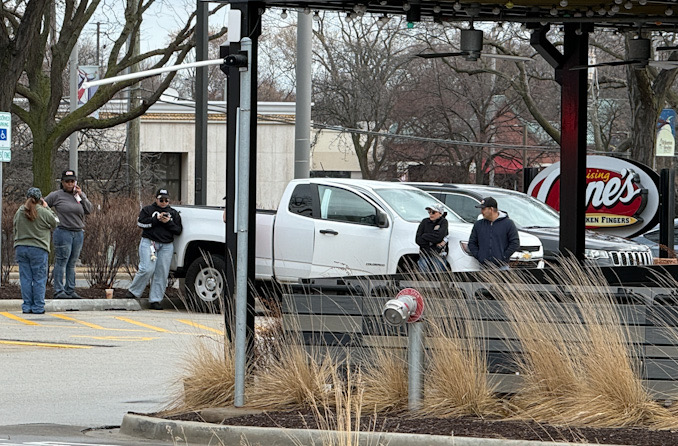Employees at Raising Cane's Arlington Heights wait outside at the front of the restaurant after they extinguished a fryer fire with a fire extinguisher, and while firefighters make sure the scene is secure on Saturday morning, March 7, 2026 at 225 East Palatine Road in Arlington Heights (CARDINAL NEWS)