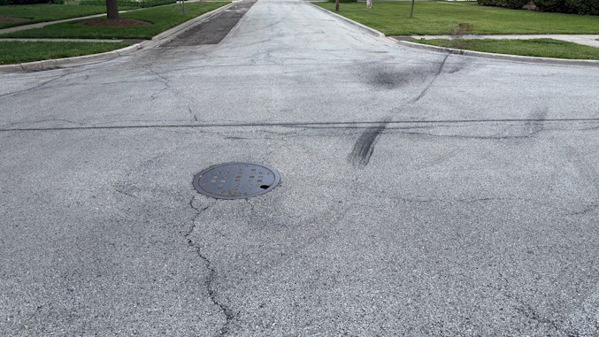 Skid marks from white compact SUV after it was pushed toward the right on St. James Street and off the road onto private property by the black sedan on Monday afternoon, May 20, 2026 (CARDINAL NEWS)