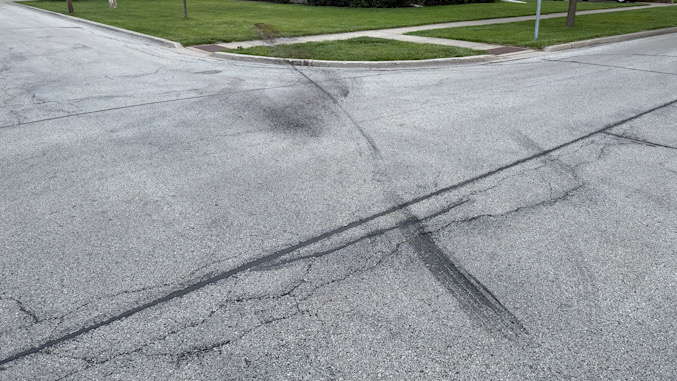 Skid marks from white compact SUV after it was pushed toward the right on St. James Street and off the road onto private property by the black sedan on Monday afternoon, May 20, 2026 (CARDINAL NEWS)