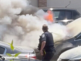 An Arlington Heights police officer attempts to extinguish a vehicle fire with a fire extinguisher while Arlington Heights firefighters were delayed for an unknown reason. SInce police officers are often already on the street, they often arrive first at risky scene and are often placed in harm's way before firefighters arrive (CARDINAL NEWS)