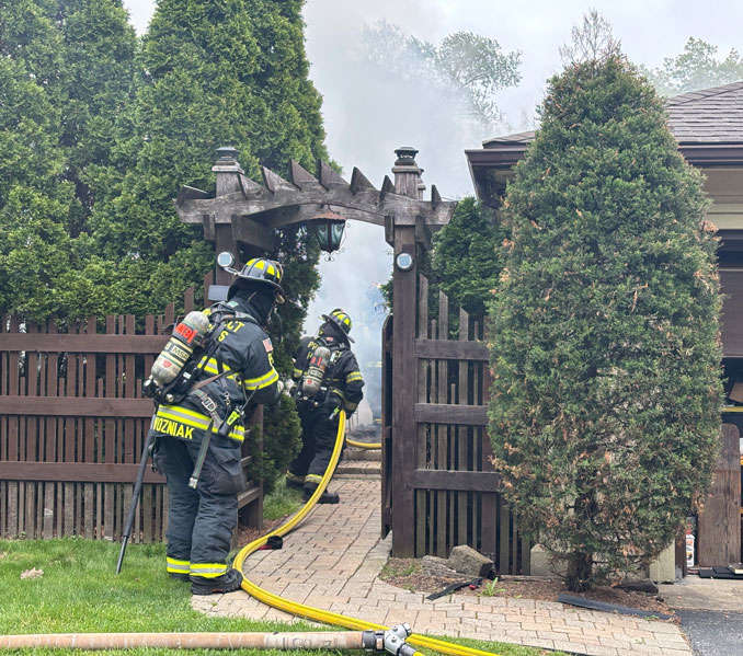 Prospect Heights Firefighters advance a hose line to the Cabana structure in the backyard on Marberry Place in Prospect Heights on Tuesday, May 2, 2026 (SOURCE: Prospect Heights Fire Protection District)