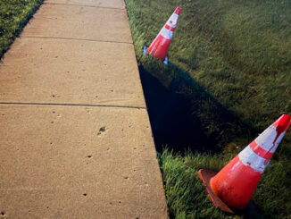 A few hours after a dangerous sinkhole that was hard to detect at night was reported by CARDINAL NEWS on Tuesday evening, July 7, 2026, Arlington Heights public works placed two cones next to the sinkhole, but left it exposed with a fall risk overnight until a tape barrier was placed around the sinkhole on Wednesday (CARDINAL NEWS).