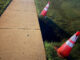 A few hours after a dangerous sinkhole that was hard to detect at night was reported by CARDINAL NEWS on Tuesday evening, July 7, 2026, Arlington Heights public works placed two cones next to the sinkhole, but left it exposed with a fall risk overnight until a tape barrier was placed around the sinkhole on Wednesday (CARDINAL NEWS).