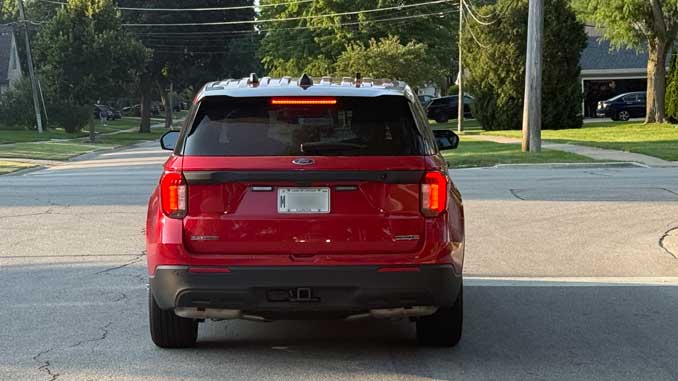 Unmarked red Ford Interceptor "flat top" (without a roof-mounted lightbar) with no official markings or designations, with an M-plate, which is a special registration plate assigned to vehicles owned and operated by local city or village governments, including municipal police vehicles, fire vehicles, public works vehicles, and official vehicles for official use (CARDINAL NEWS)