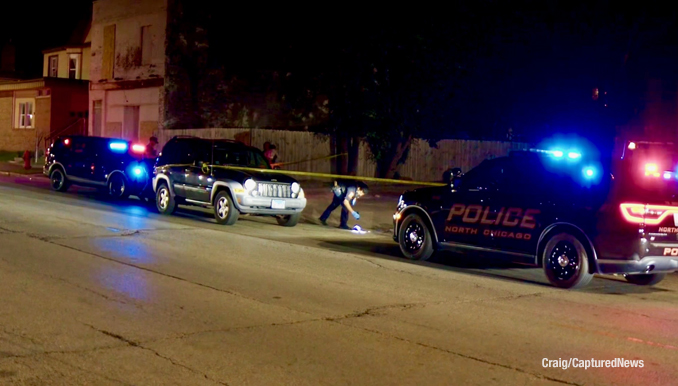 Police investigate a fatal stabbing crime scene near a Jeep Liberty on 10th Street in North Chicago (PHOTO CREDIT: Craig/CapturedNews).